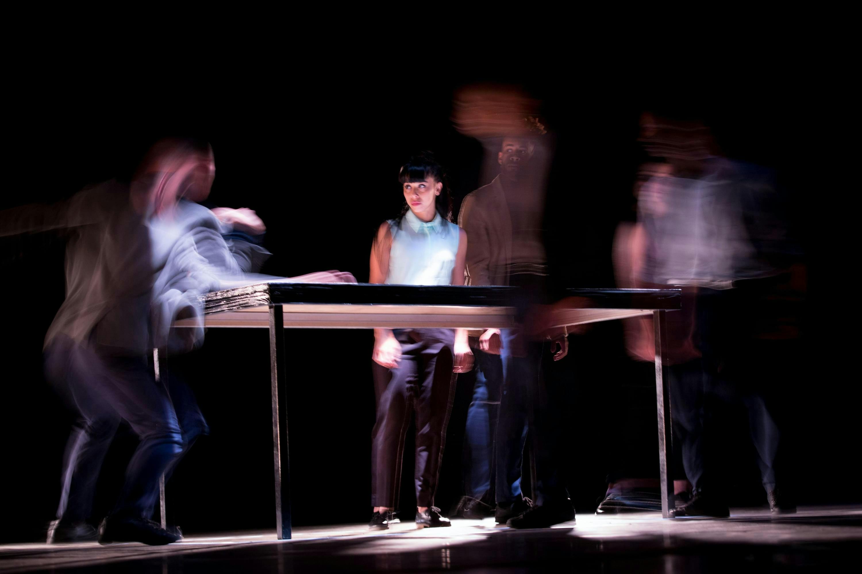 Vier mensen bewegen rondom dezelfde tafel. De foto is gemaakt met een multiple exposure effect, hierdoor worden de bewegingen zichtbaar maar tegelijkertijd abstract. Innovatief werken is meebewegen met veranderende situaties.
