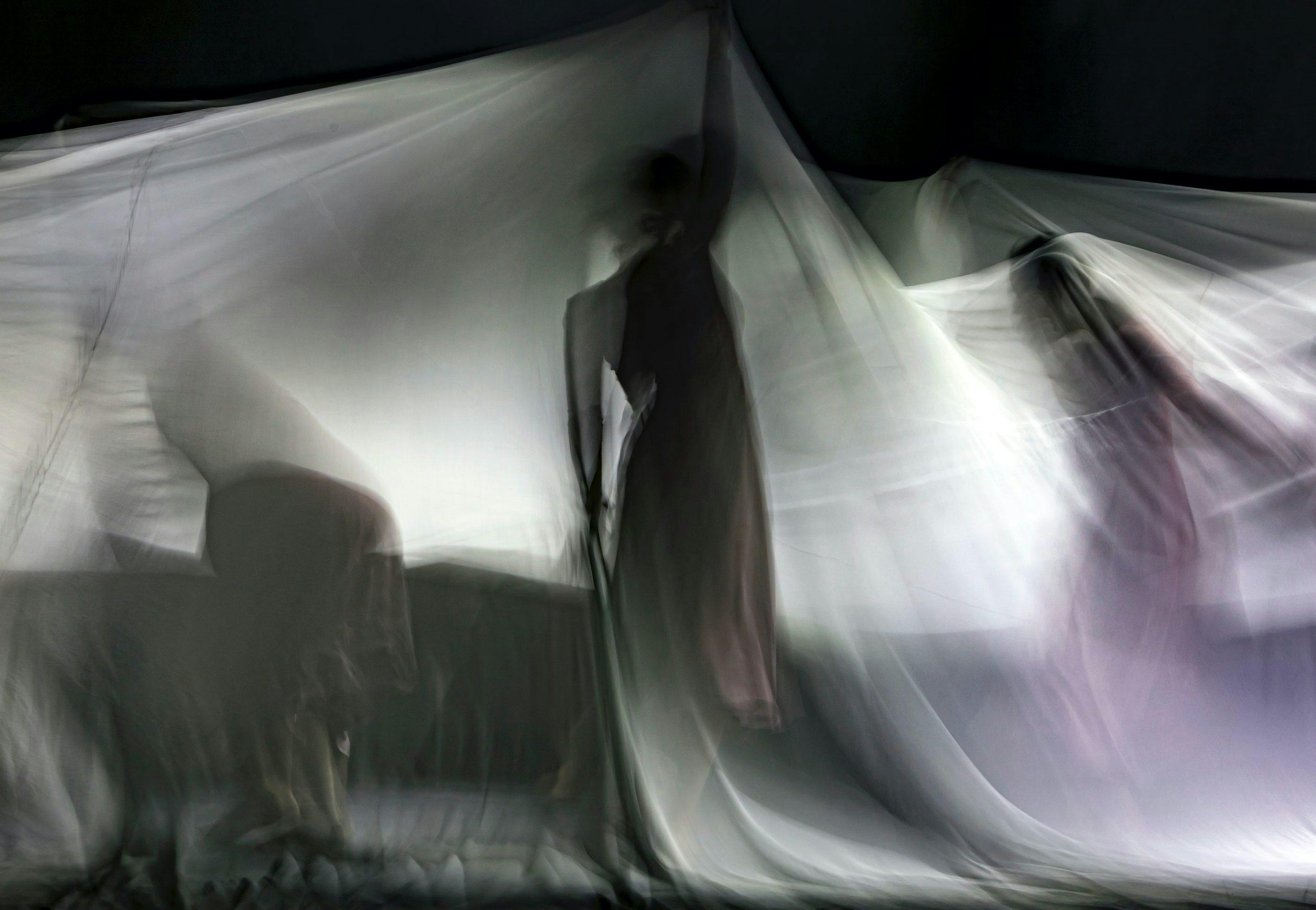 Performers verborgen achter een wit doek
