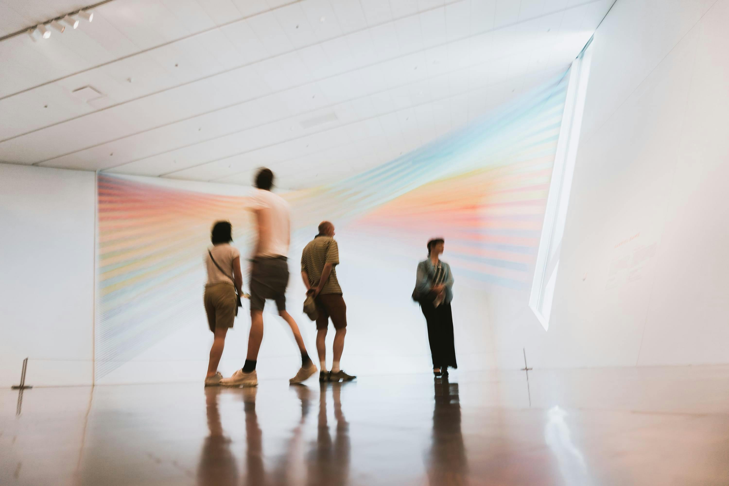 Mensen in een museum met een lichtprojectie op de achtergrond