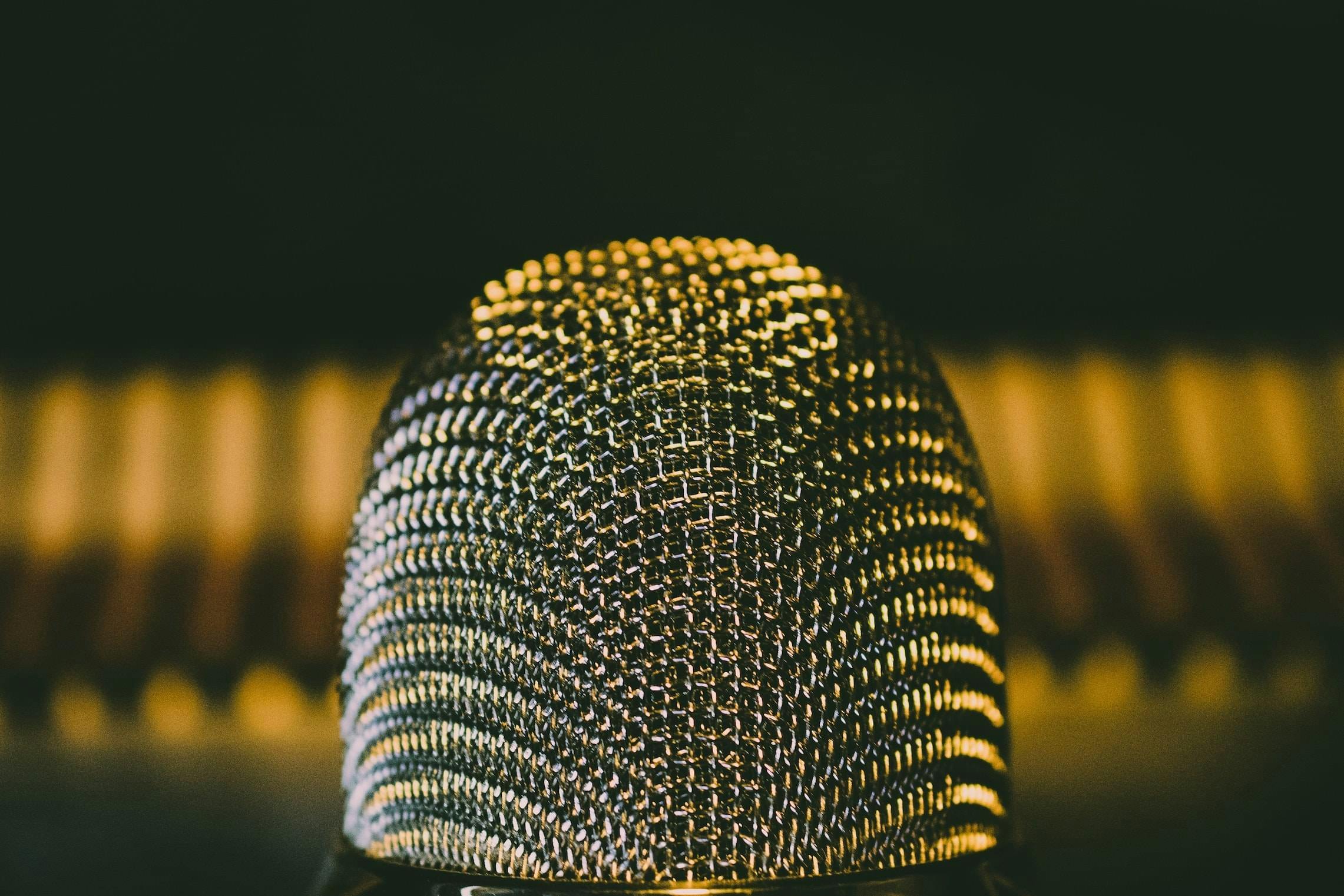 Close-up foto van een microfoon teen een donkere achtergrond