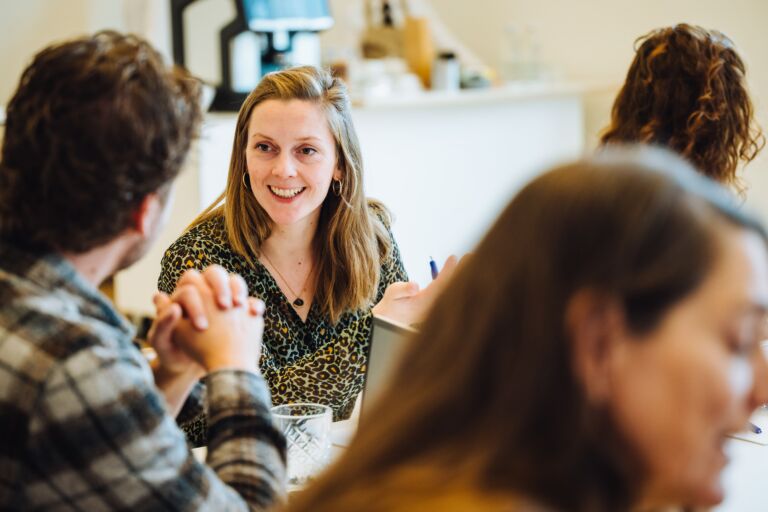 Lachende vrouw in een workshop setting