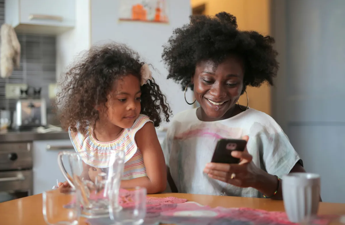 A woman and a child looking at a phone