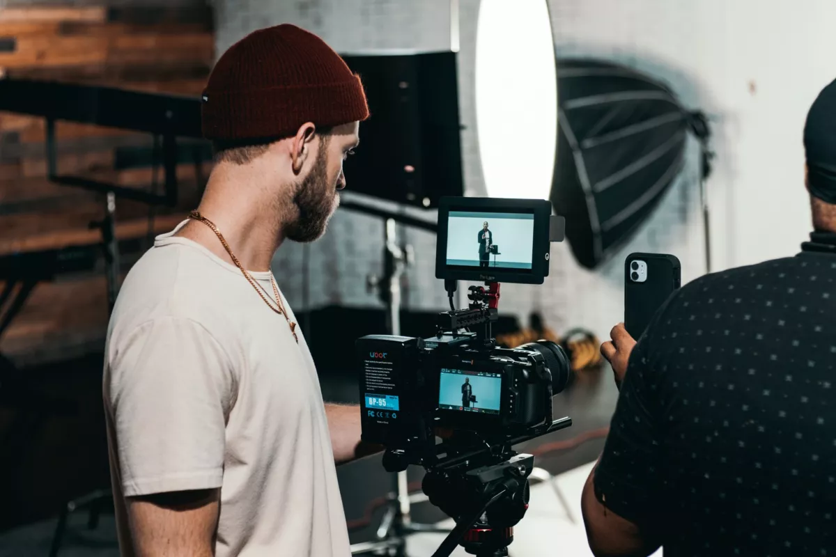 Twee makers op een filmset. In het schermpje van de camera is te zien dat er iemand gefilmd wordt.