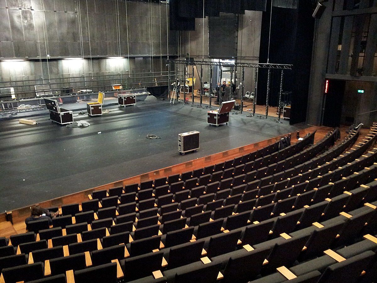 Afbeelding van een lege stadsschouwburg in Amsterdam. Foto is vanuit de zaal genomen. Op het podium staan lichten en apparatuur.