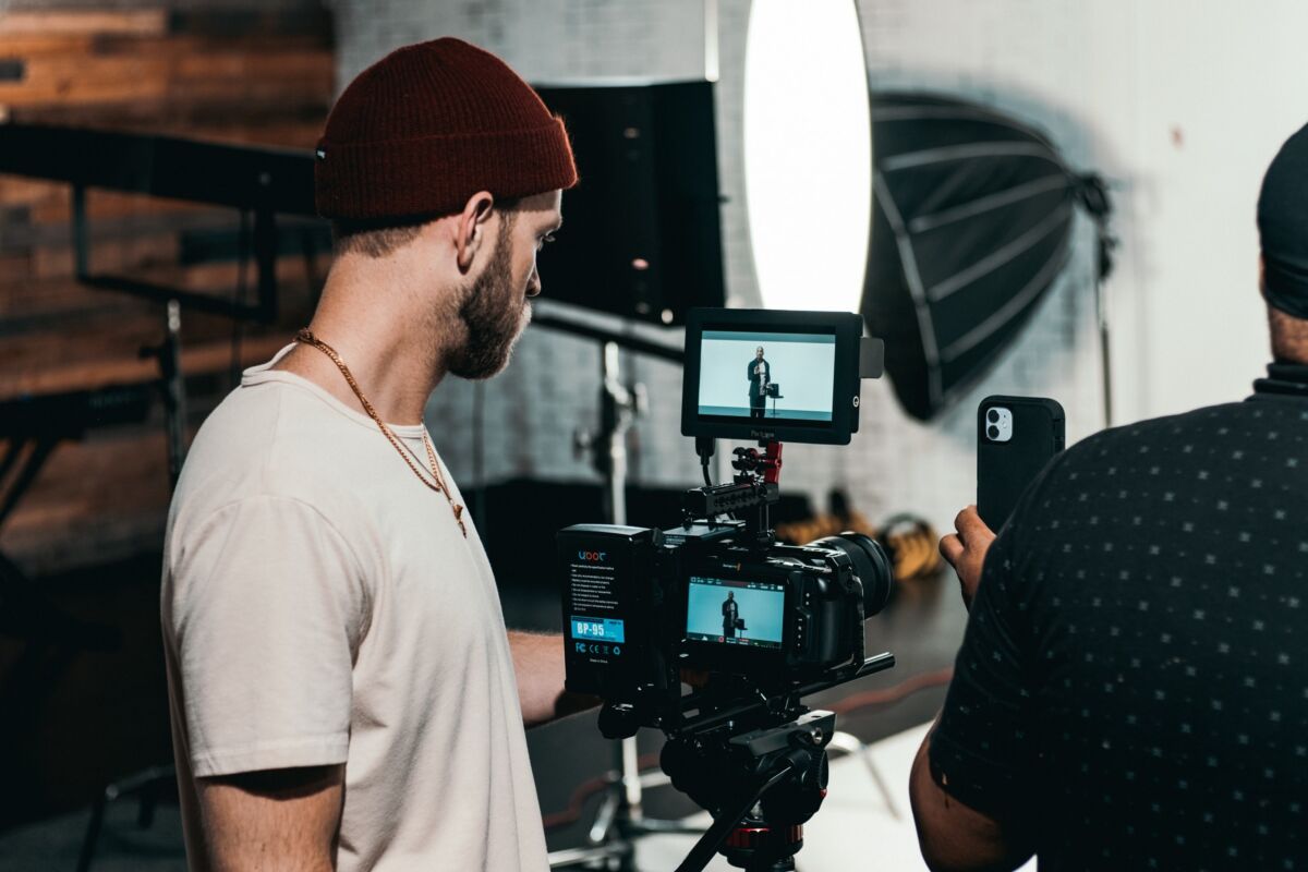 Twee makers op een filmset. In het schermpje van de camera is te zien dat er iemand gefilmd wordt.