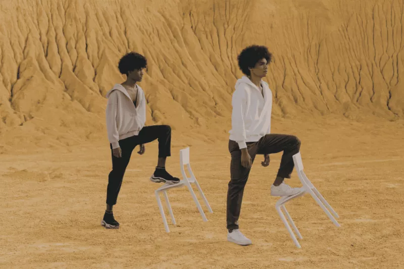 Jongens op stoelen in woestijn