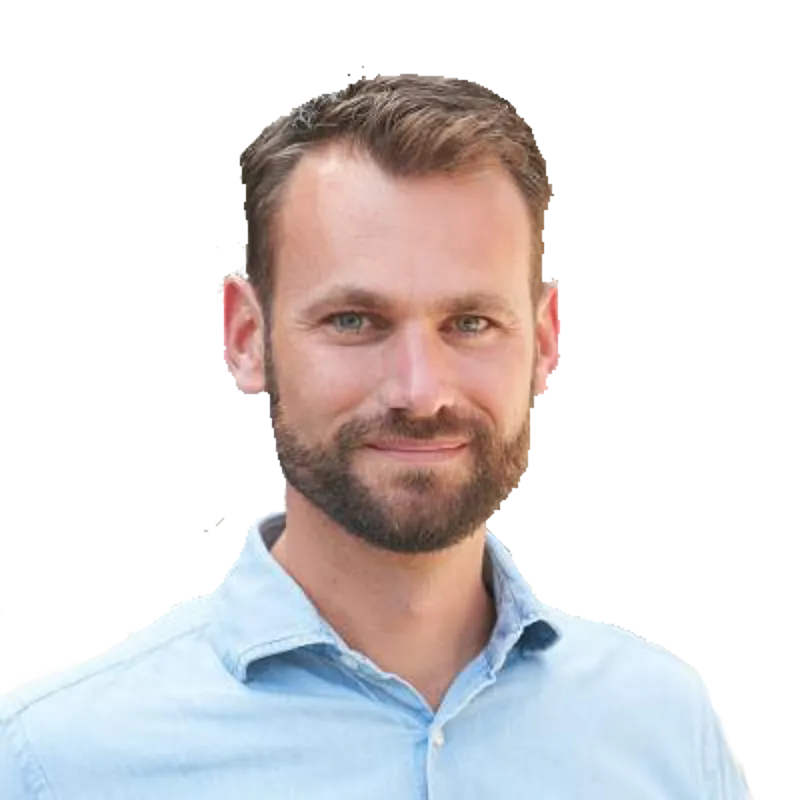 Portret van een man met kort haar en een baard in een lichtblauw overhemd.