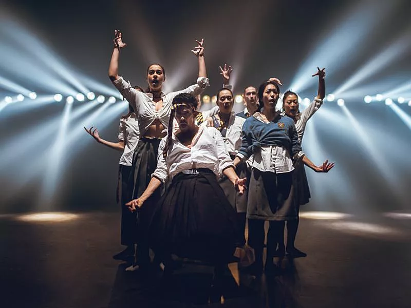 Dansers op een podium, met lichten die het publiek in schijnen