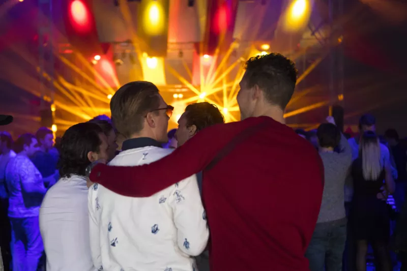 In de verte de lichten van het podium, op de voorgrond zie je bezoekers.